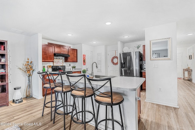 kitchen with a center island with sink, sink, stainless steel refrigerator with ice dispenser, light hardwood / wood-style flooring, and black range with electric cooktop