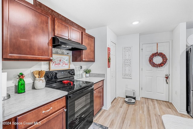 kitchen featuring electric range, light hardwood / wood-style floors, and a textured ceiling