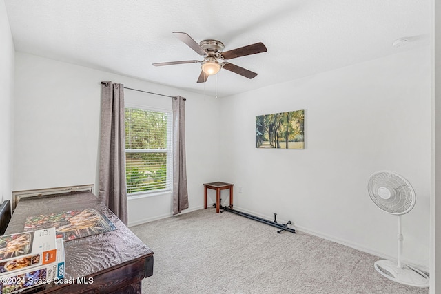 bedroom featuring a textured ceiling, ceiling fan, and light carpet