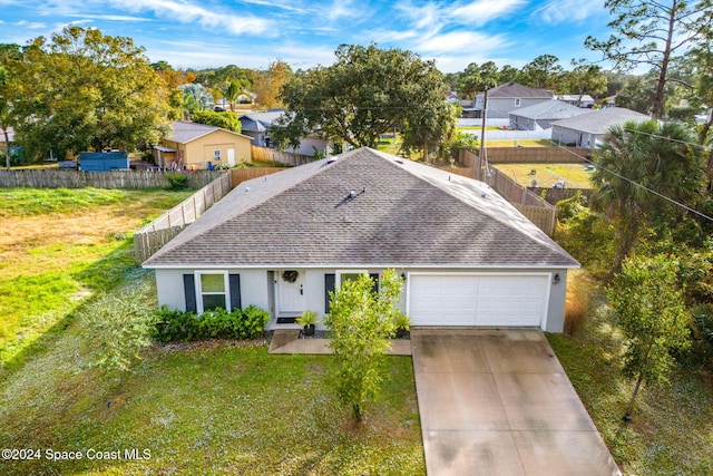 single story home featuring a garage and a front lawn