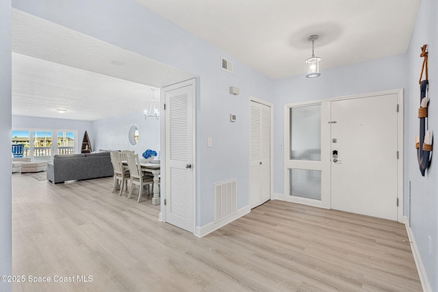 foyer entrance featuring french doors and light hardwood / wood-style floors