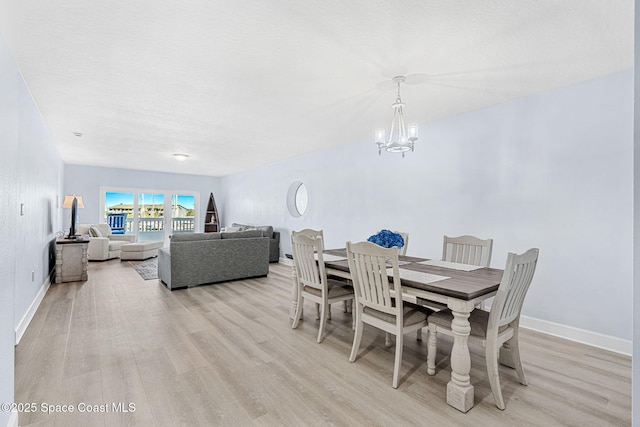 dining space with a chandelier and light hardwood / wood-style floors