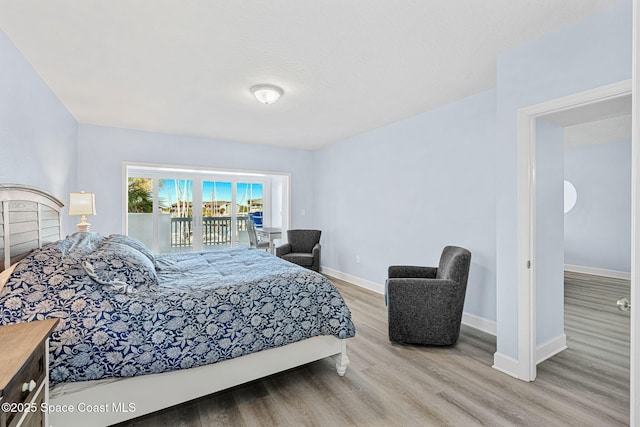 bedroom with access to outside and light hardwood / wood-style flooring