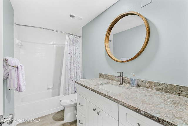 full bathroom with shower / tub combo with curtain, vanity, hardwood / wood-style floors, and toilet