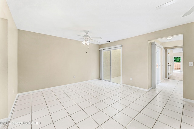 tiled spare room featuring ceiling fan