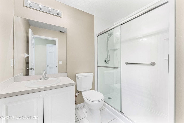 bathroom featuring tile patterned floors, a textured ceiling, toilet, a shower with door, and vanity