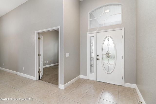 entrance foyer with light tile patterned floors and a towering ceiling