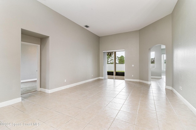 tiled empty room with a high ceiling