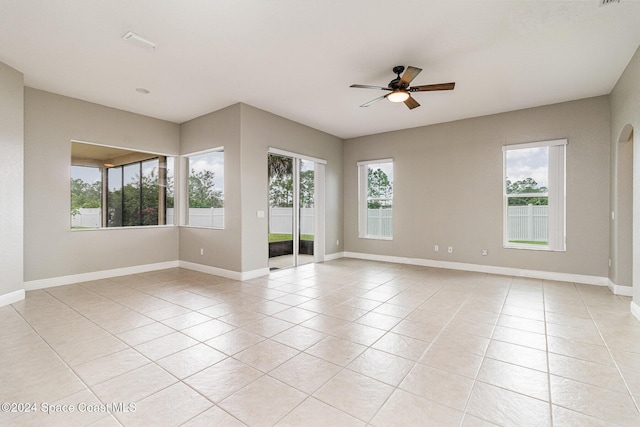 empty room with light tile patterned floors and a healthy amount of sunlight