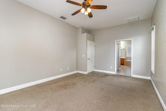 unfurnished bedroom with ceiling fan, light carpet, and connected bathroom