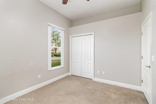 unfurnished bedroom featuring light carpet, a closet, and ceiling fan