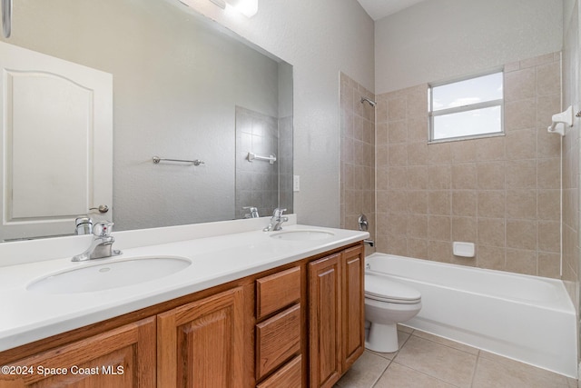 full bathroom with tile patterned flooring, vanity, tiled shower / bath combo, and toilet