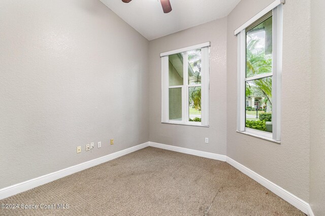 empty room with ceiling fan, carpet floors, and lofted ceiling