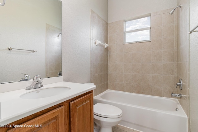 full bathroom with vanity, tiled shower / bath combo, and toilet