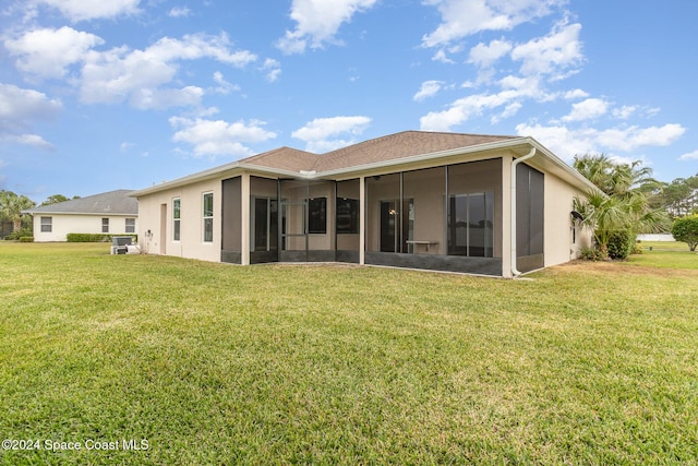 rear view of property featuring a sunroom and a yard