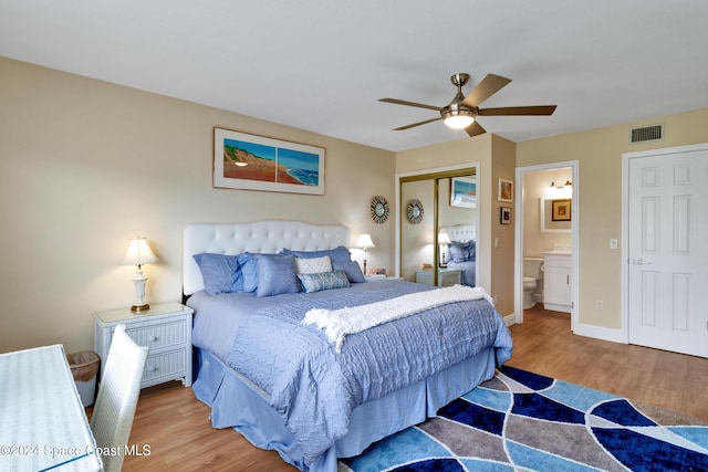 bedroom featuring ensuite bath, ceiling fan, a closet, and wood-type flooring