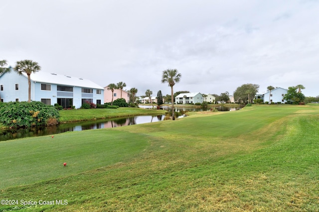 surrounding community featuring a water view and a lawn