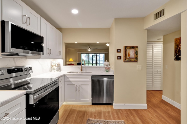 kitchen featuring white cabinets, stainless steel appliances, light hardwood / wood-style flooring, and sink