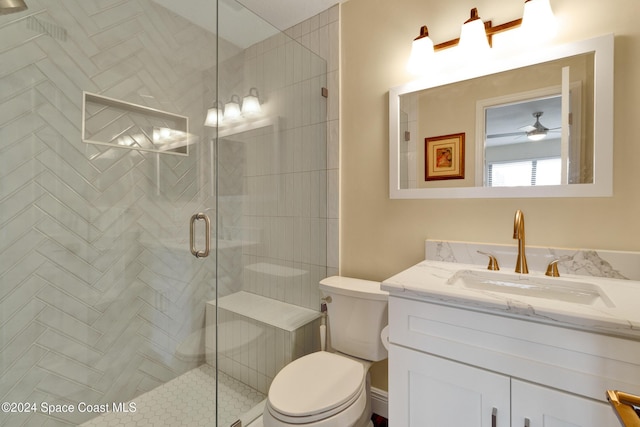 bathroom with toilet, ceiling fan, an enclosed shower, and vanity