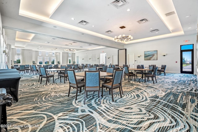 dining space with carpet floors and a tray ceiling