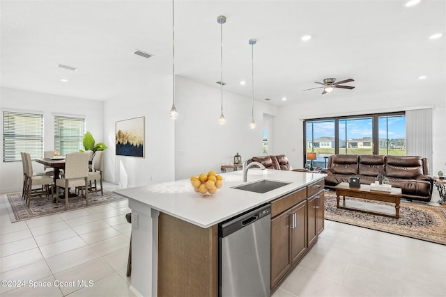 kitchen with ceiling fan, sink, decorative light fixtures, a center island with sink, and dishwasher