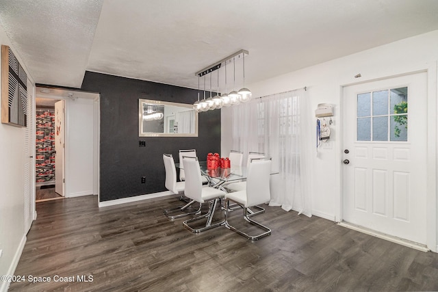 dining room featuring dark hardwood / wood-style flooring and a textured ceiling