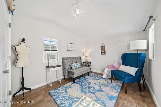 living area with dark hardwood / wood-style flooring, cooling unit, vaulted ceiling, and a notable chandelier