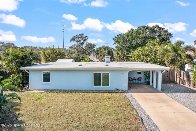 ranch-style home featuring a carport and a front lawn