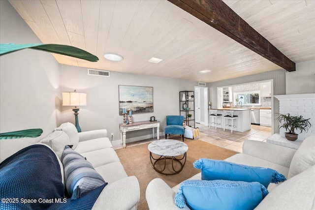 tiled living room featuring beamed ceiling, wooden ceiling, and a fireplace