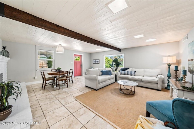 living room featuring beam ceiling, a fireplace, and light tile patterned floors