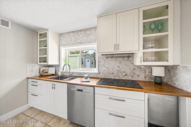 kitchen with wood counters, dishwasher, black electric stovetop, sink, and white cabinetry