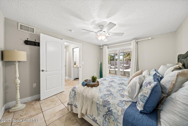 bedroom featuring ceiling fan, light tile patterned floors, and a textured ceiling