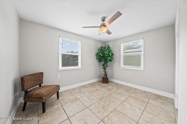 sitting room with light tile patterned floors, a textured ceiling, a wealth of natural light, and ceiling fan