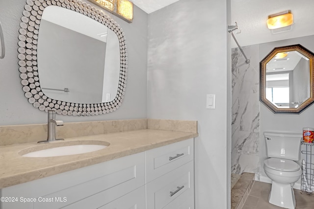 bathroom featuring tile patterned floors, a shower, vanity, and toilet