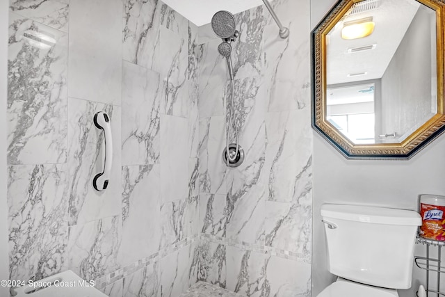 bathroom with toilet and tiled shower