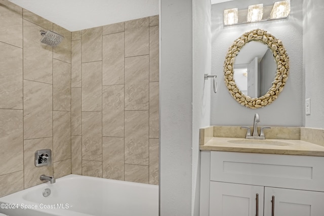 bathroom featuring vanity and tiled shower / bath