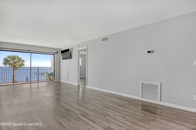 empty room featuring a textured ceiling and hardwood / wood-style flooring