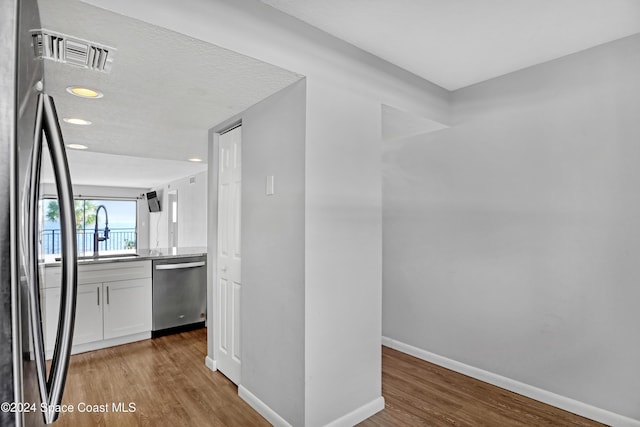 hall featuring hardwood / wood-style floors and sink