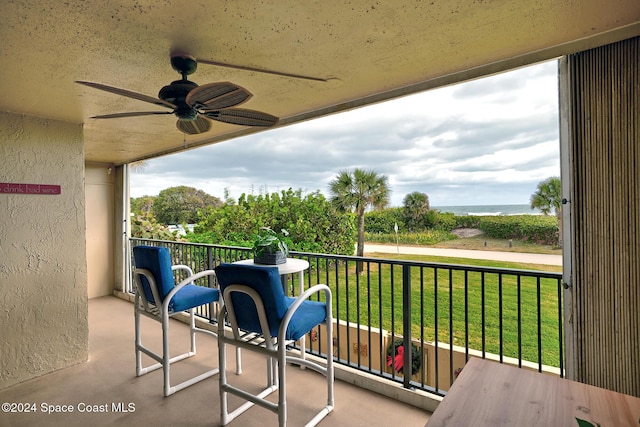 balcony with ceiling fan and a water view