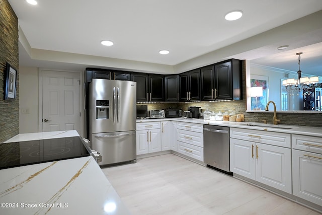 kitchen with white cabinetry, sink, a chandelier, decorative backsplash, and appliances with stainless steel finishes