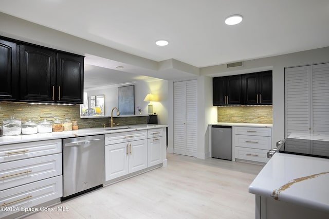 kitchen with refrigerator, sink, stainless steel dishwasher, tasteful backsplash, and white cabinetry