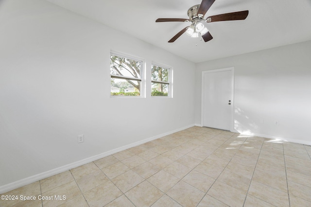 empty room with ceiling fan and light tile patterned floors