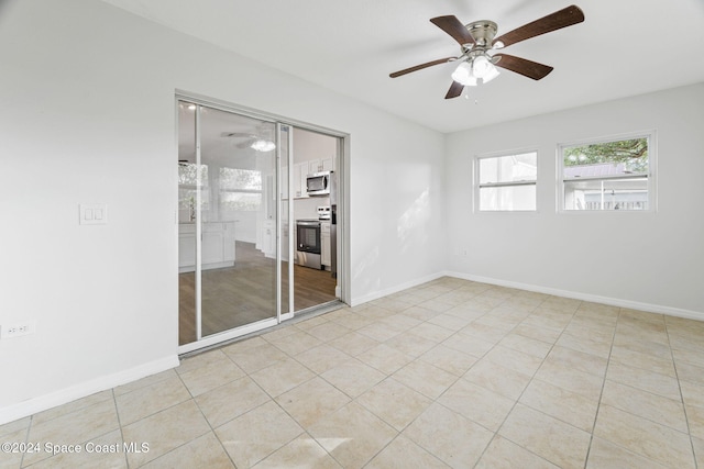 unfurnished room with ceiling fan and light tile patterned floors