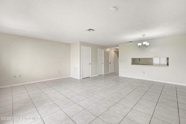 unfurnished living room featuring light tile patterned floors, a textured ceiling, and a notable chandelier