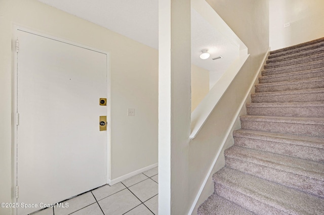 stairway featuring tile patterned flooring