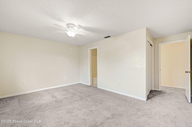 carpeted spare room with a textured ceiling and ceiling fan