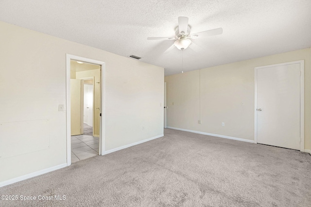 carpeted empty room featuring ceiling fan and a textured ceiling