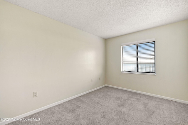 carpeted empty room featuring a textured ceiling