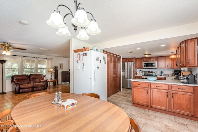 dining room with a textured ceiling and ceiling fan with notable chandelier