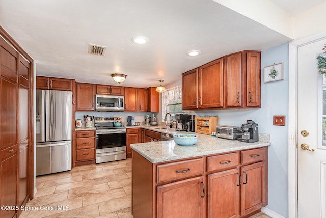 kitchen with kitchen peninsula, stainless steel appliances, light stone counters, and sink